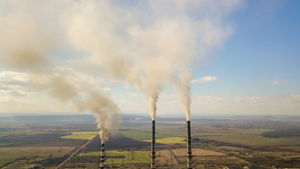 tall-pipes-of-power-plant-white-smoke-on-rural-land